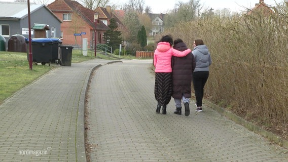 Drei Personen Arm in Arm auf einer Straße laufend © Screenshot 