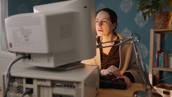 Eine Frau vor einem alten Computer. © NDR 