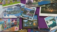 Viele bunte Postkarten hängen an einer Wand © Screenshot 