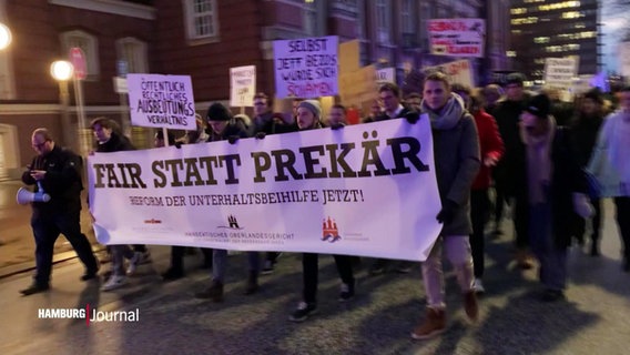 Protestierende Menschen halten ein Banner mit der Aufschrift "Fair statt Prekär" © Screenshot 