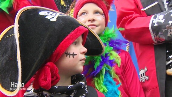 Verkleidete Kinder sehen sich einen Karnevalsumzug an. © Screenshot 