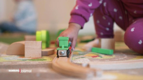 Ein Mädchen spielt mit der Spielzeug-Eisenbahn. © Screenshot 