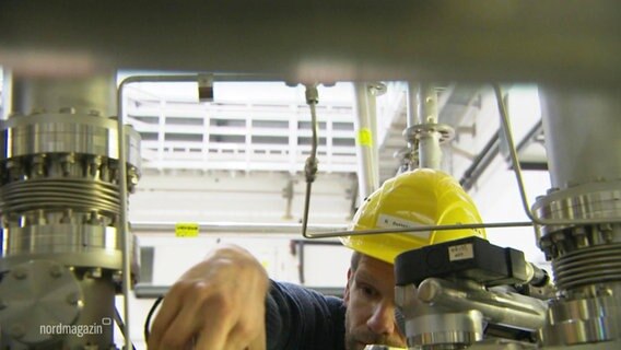 Ein Ohysiker baut an einem Bauteil des Wendelstein 7-X. © Screenshot 