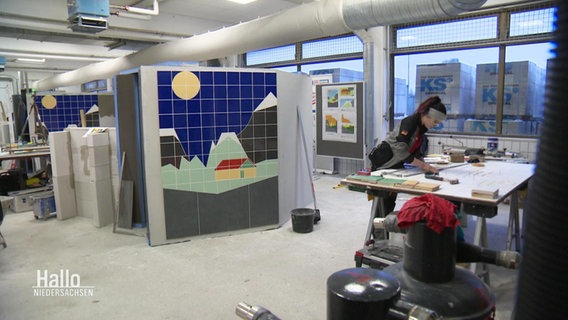 Eine Werkstatt mit Stellwänden auf denen Wandfliesen verlegt sind. © Screenshot 