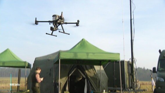 Eine Drohne über zwei grünen Zelten. © Screenshot 