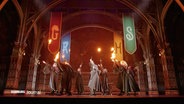 Das Bühnenbild von Harry Potter mit Personen mit funkenden Zauberstäben © Screenshot 