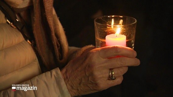 Eine Seniorin hält eine Kerze © Screenshot 