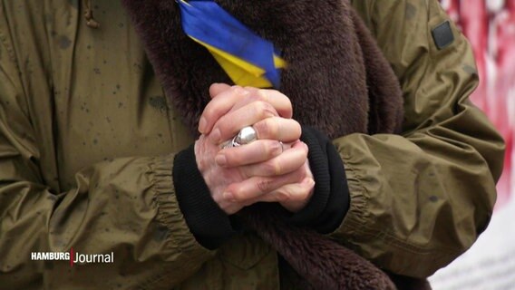 Eine Frau betet wohl für das Ende des Krieges in der Ukraine. © Screenshot 