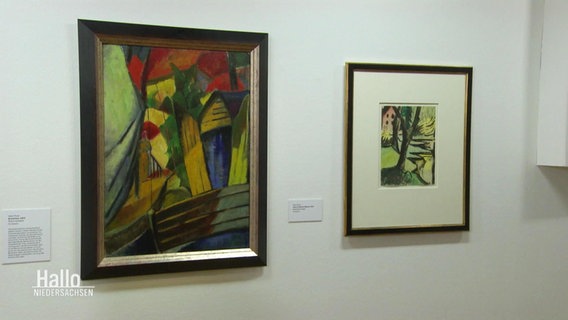 An einer Wand hängen zwei eingerahmte expressionistische Gemälde in bunter Farbgebung. Daneben sind erklärende Ausstellungstexte angebracht. © Screenshot 