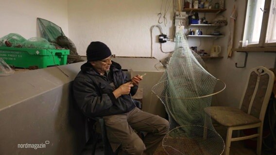 Ein Krabbenfischer repariert ein Netz. © Screenshot 