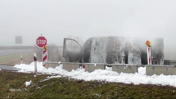 Ein ausgebrannter Geldtransporter steht auf einer Autobahn. © Screenshot 