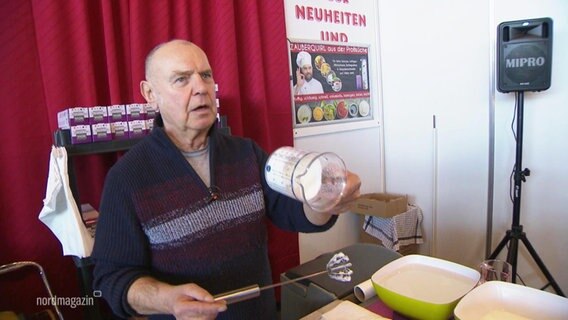 Hubert Santin demonstriert einen Milchschaumquirl auf der Ostseemesse. © Screenshot 
