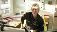 Die Dorfpolizistin Anja Johannsmann in Uniform am Schreibtisch. © Screenshot 