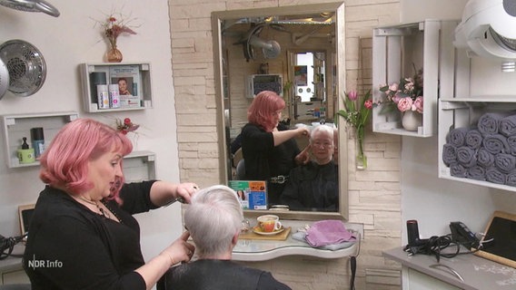 Friseurmeisterin Claudia Schmidt bei der Arbeit im Gespräch mit einer Kundin. © Screenshot 