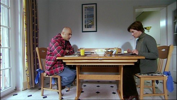 Eine Frau und ein Mann sitzen an einem Tisch. © Screenshot 