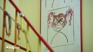 In einer Schule hängt ein Selbstportrait eines sehr wütenden rothaarigen Mädchens. © Screenshot 