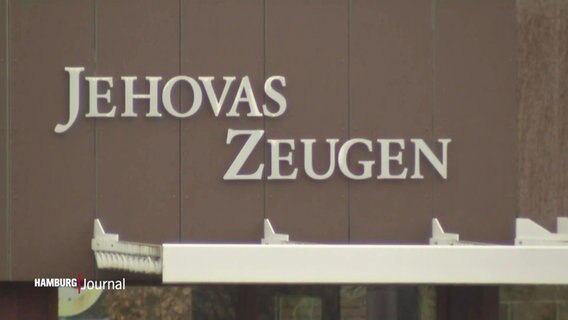 Auf einer Wand ist der Schriftzug "Jehovas Zeugen" angebracht. © Screenshot 