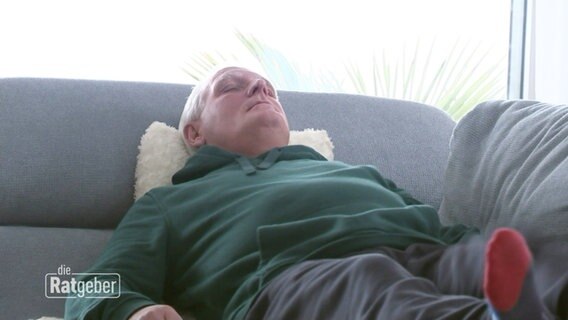 Ein Mann liegt erschöpft auf dem Sofa. © Screenshot 