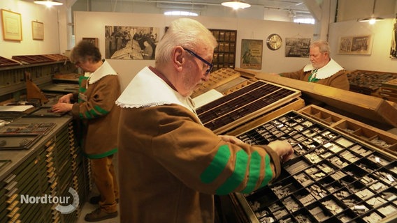 Männer im Museum Rendsburg bereiten sich auf Tag der Druckkunst vor. © Screenshot 