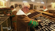 Männer im Museum Rendsburg bereiten sich auf Tag der Druckkunst vor. © Screenshot 