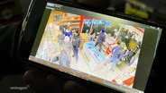 Bilder einer Überwachungskamera zeigen Personen beim Plündern einer Tankstelle © Screenshot 