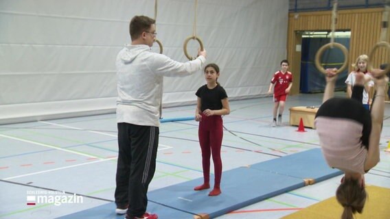 Ein Trainer betreut Schüler*innen beim Schulsport. © Screenshot 