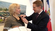 Ministerpräsident Günther verleiht Inna Shames das Bundesverdienstkreuz. © Screenshot 
