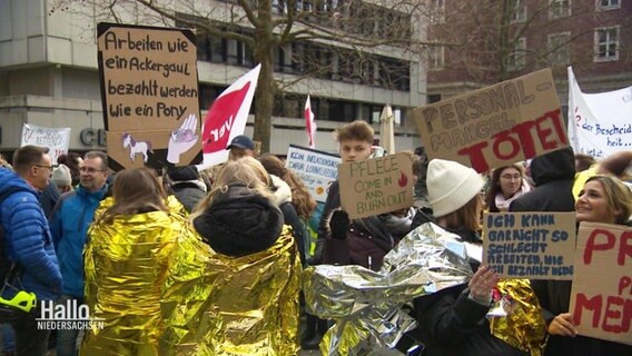 Menschen demonstrieren für bessere Arbeitsbedingungen. © Screenshot 