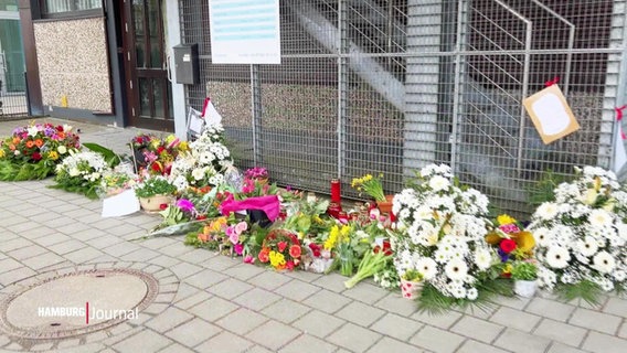 Blumensträuße und Kerzen liegen vor dem Tatort . © Screenshot 