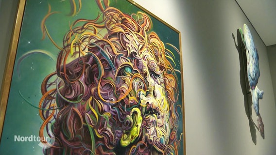 Kunstwerk von Glenn Brown in einer Ausstellung: Ein Kopf, vollkommen umwirbelt von farbigen Locken, vor einem grünen Hintergrund © Screenshot 