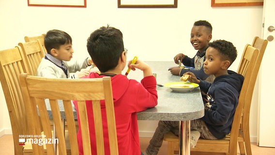 Fünf Kinder an einem Esstisch im Kinderspielzentrum. © Screenshot 