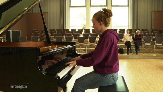 Eine junge Frau mit lila Pullover spielt auf einem Konzertflügel. © Screenshot 
