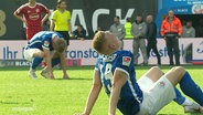 Enttäuschte Spieler von Hansa Rostock sitzen auf dem Rasen. © Screenshot 