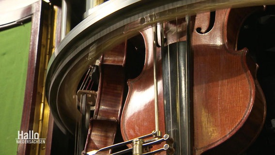 Eine Geige in einem machanischen Gerät. © Screenshot 