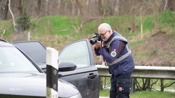 Ein Mitarbeiter der Polizei fotografiert den Fluchtwagen. © Screenshot 