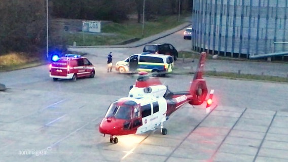 Ein Helikopter im Vordergrund, dahinter einige Einsatzfahrzeuge © Screenshot 