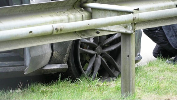 Ein Platter Reifen an einem Auto vor einer Leitplanke © Screenshot 