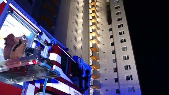 Im Vordergrund ein Teil eines Feuerwehrfahrzeuges, im Hintergrund ein Hochhaus. © Screenshot 