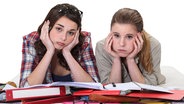 Zwei traurig schauende Studentinnen über ihren Lernunterlagen. (extra 3 vom 23.03.2023 im Ersten) © NDR 