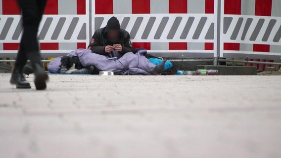 Eine Obdachlose Person in einer Fußgängerzone © Screenshot 