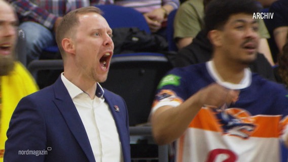 Trainer Christian Held steht bei einem Basketballspiel am Spielfeldrand und schreit. © Screenshot 