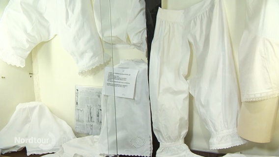 Weiße, spitzenbesetzte historische Unterwäsche. © Screenshot 