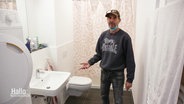 Franz Bauer zeigt sein Badezimmer im Projekt "Housing First" in Hannover. Früher lebte er auf der Straße. © Screenshot 