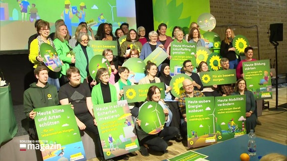 Mehrere Parteimitglieder der Grünen stehen mit Plakaten zu einem Fotoshooting bereit. © Screenshot 