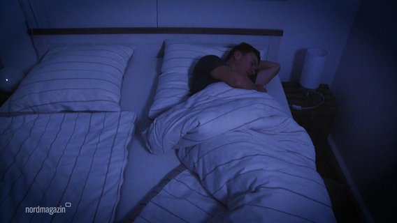Ein Mann schläft in einem Doppelbett. © Screenshot 