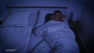 Ein Mann schläft in einem Doppelbett. © Screenshot 