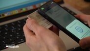 Eine studierende Person versucht einen Personalausweis mit dem Handy zu scannen. © Screenshot 