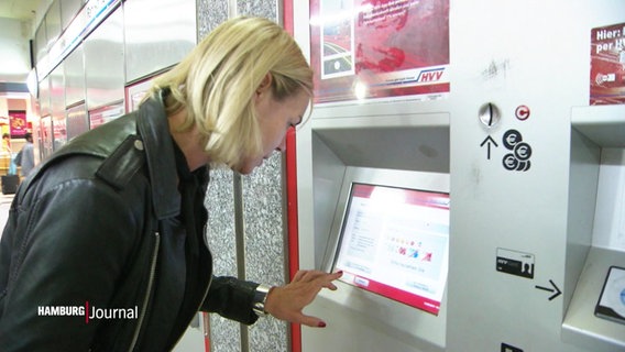 Eine Person bedient einen Fahrkartenautomaten. © Screenshot 