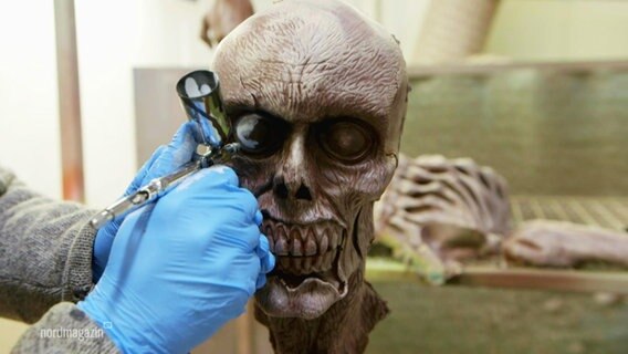 Totenkopf-Figur wird mit Airbrush-Pinsel bemalt. © Screenshot 