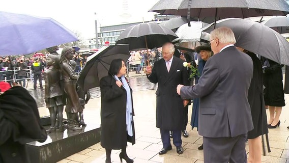 König Charles kommt im Regen am Bahnhof Dammtor an. Blumen in Camillas Arm. © Screenshot 